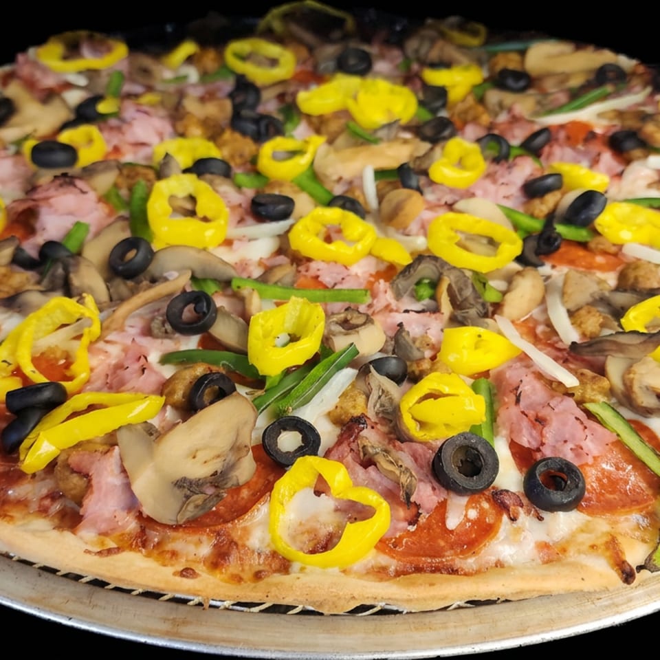 Loaded pizza topped with pepperoni, ham, mushrooms, black olives, banana peppers, onions, and green peppers on a metal tray.